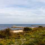 Non ci resta ora che superare il muretto a ridosso della strada per scendere nella foce del torrente, inclusa da due argini che si allungano nel mare